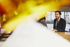 Business man and woman having a conversation in an office. Primary colors: yellow and white.