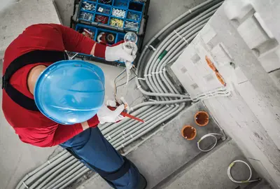 Top view of electrician checking wires while performing electrical wiring installation.