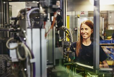 Woman operating a machine on a production site. 