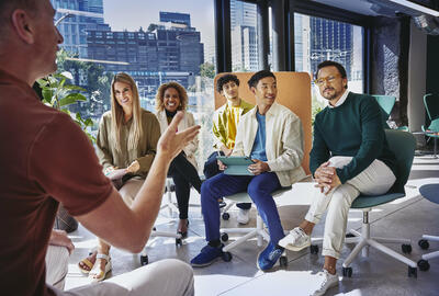 Group of people having a meeting, in a room with glass windows