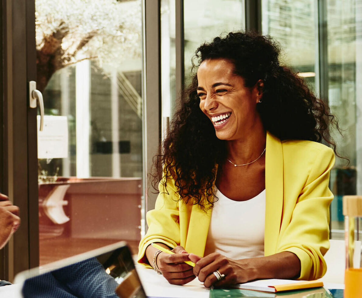 male and female talking and having a laugh at the office