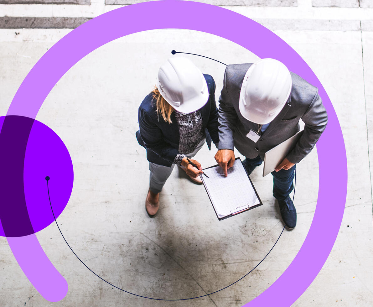A top view of an industrial man and woman engineer with clipboard in a factory.