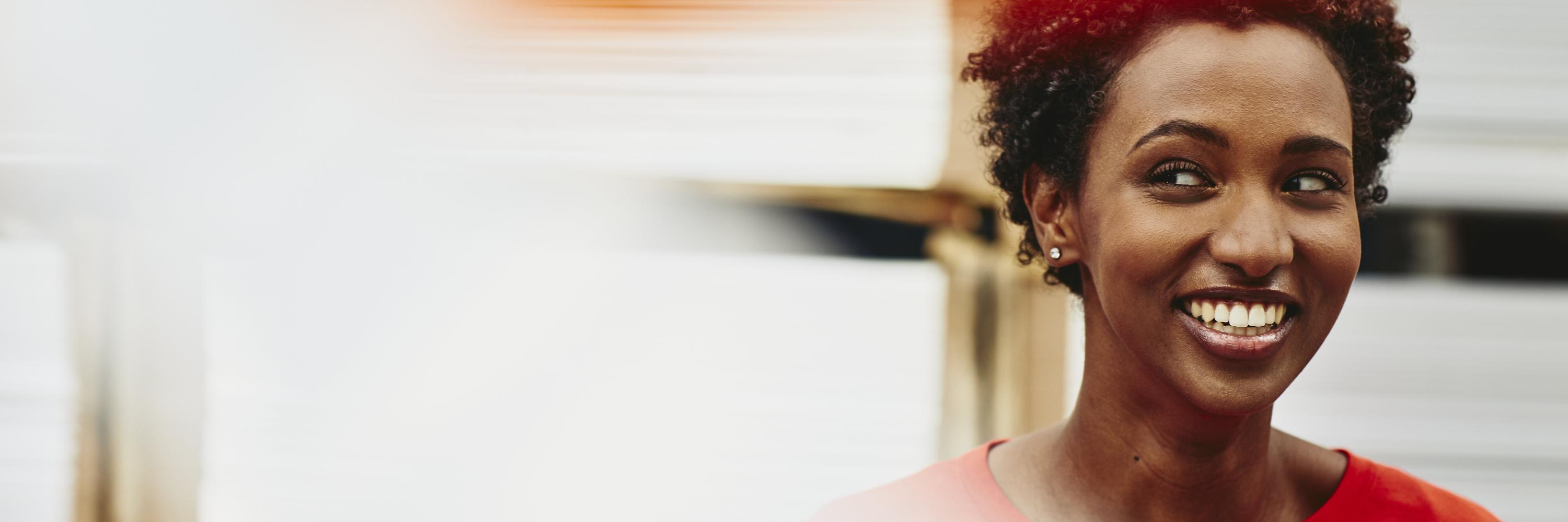 Female African-American worker. Lauging. Primary color orange. Secondary colors white/cream and red.