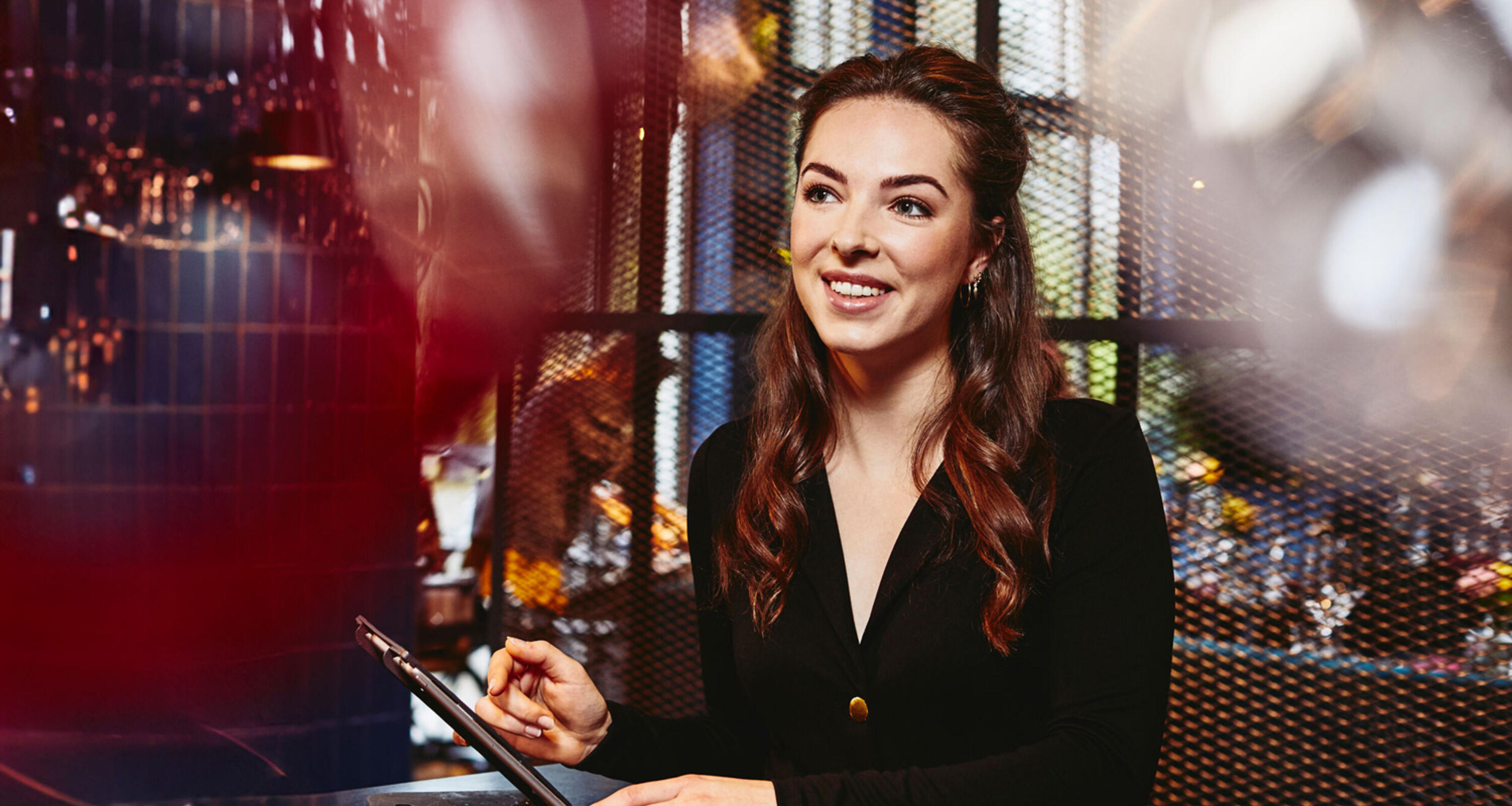 Smiling female looking away, behind the reception desk