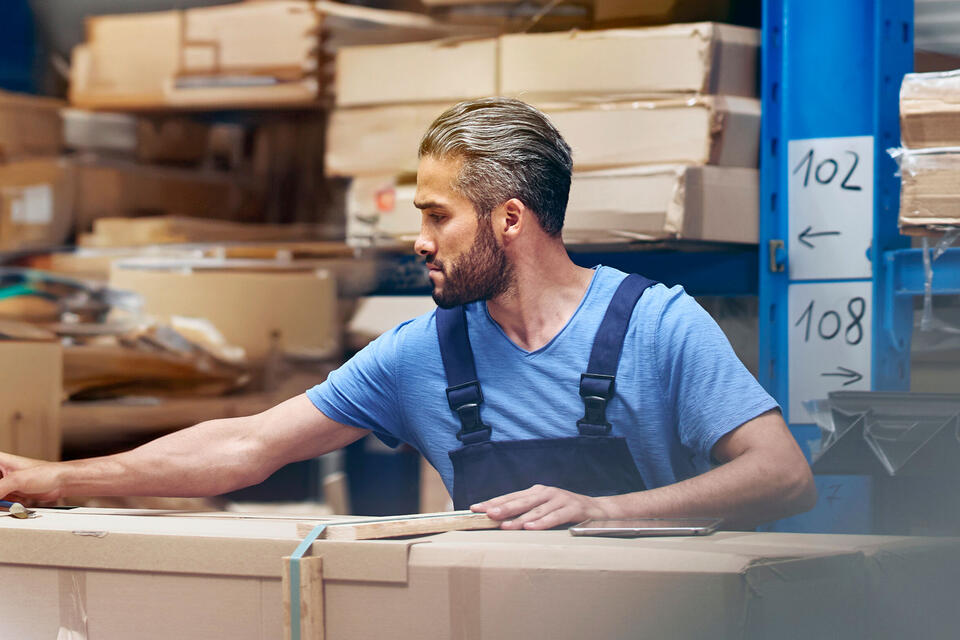 male busy with parcels in a distribution center/warehouse.