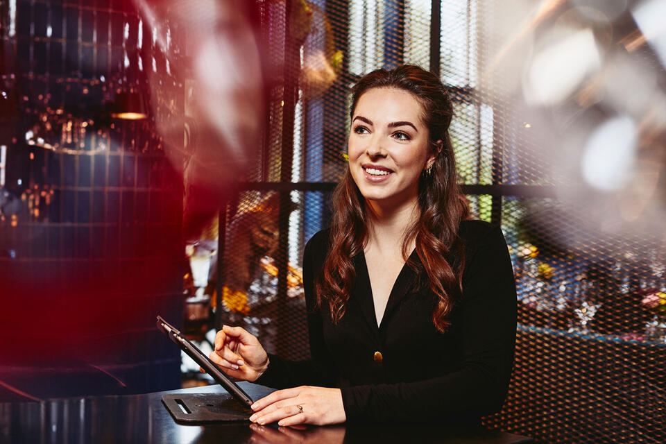 Smiling female looking away, behind the reception desk