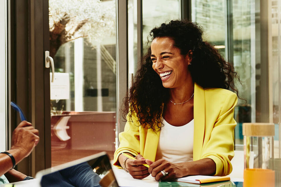male and female talking and having a laugh at the office