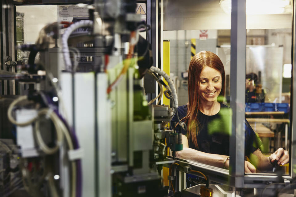 mujer sonriente operando una máquina
